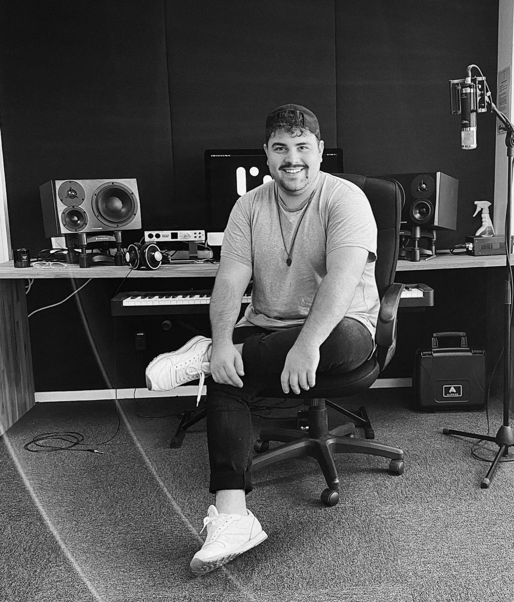 Yan sourit face à l'objectif, assis devant une console de studio à LIMPI en Norvège